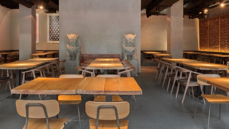 Modernes Restaurant mit Holztischen, Stühlen und asiatischen Dekorationen. Dezente Beleuchtung und kunstvolle Wandgestaltung schaffen eine einladende Atmosphäre., © Breitengrad17, Stuttgart