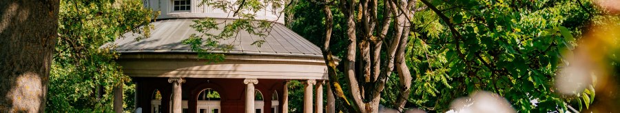 A round teahouse with pillars in Weissenburg Park, surrounded by green trees and blooming flowers in the foreground., &copy; Thomas Niederm&uuml;ller
