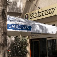 Entrance of a café called Oblamow with Gauloises parasol and plants. Exterior lighting and Franciscan and San Miguel signs visible., © SMG, Sarah Schmid Entrance of a café called Oblamow with Gauloises parasol and plants. Exterior lighting and Franciscan and San Miguel signs visible., © SMG, Sarah Schmid
