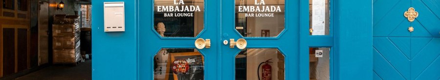 Gro&szlig;e Doppelt&uuml;r in leuchtendem Blau mit Glaseins&auml;tzen, auf denen "La Embajada Bar Lounge" in wei&szlig;en Lettern geschrieben steht., &copy; SMG Stuttgart Marketing GmbH - Sarah Schmid