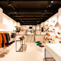 A modern clothing store with stylish furnishings, clothes on clothes rails and shoes on shelves. Bright lighting and geometric lamps., © Elisa Mauruschat A modern clothing store with stylish furnishings, clothes on clothes rails and shoes on shelves. Bright lighting and geometric lamps., © Elisa Mauruschat