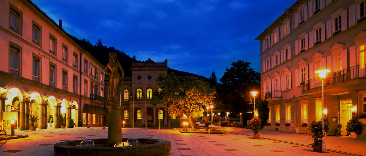 Ein beleuchteter Platz bei Nacht mit historischen Gebäuden und einer Statue im Vordergrund. Die warmen Lichter schaffen eine einladende Atmosphäre., © Mokni's Palais Hotel & Spa Ein beleuchteter Platz bei Nacht mit historischen Gebäuden und einer Statue im Vordergrund. Die warmen Lichter schaffen eine einladende Atmosphäre., © Mokni's Palais Hotel & Spa