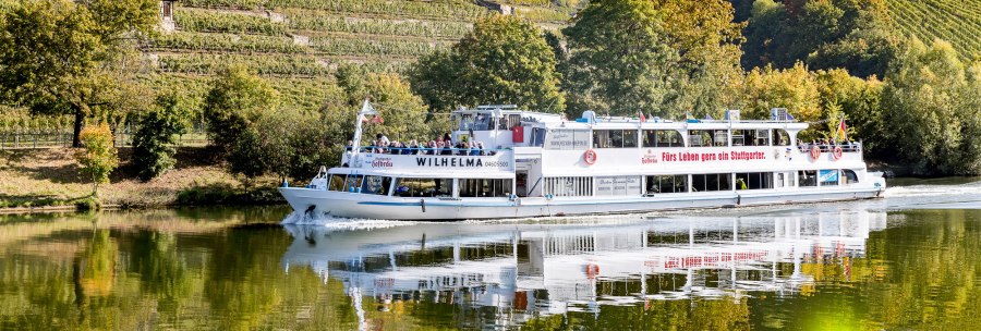 An excursion boat called Wilhelma sails on a river, surrounded by green vineyards and trees in the fall., © all copyrights are reserved by maks richter An excursion boat called Wilhelma sails on a river, surrounded by green vineyards and trees in the fall., © all copyrights are reserved by maks richter