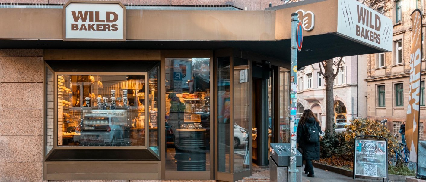 Fassade des Stores mit gro&szlig;en Schaufenstern. Durch die spiegelnden Scheiben erkennt man Backware in der Auslage., &copy; Stuttgart-Marketing GmbH, Sarah Schmid