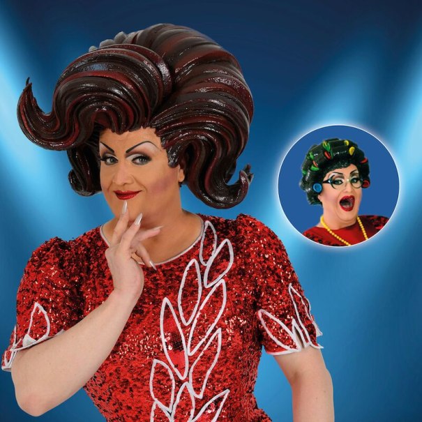 A person in a glittering red dress and a large, elaborate wig poses in front of a blue background. In the background, a smaller picture of the same person with curlers., &copy; Theaterhaus Stuttgart e.V.