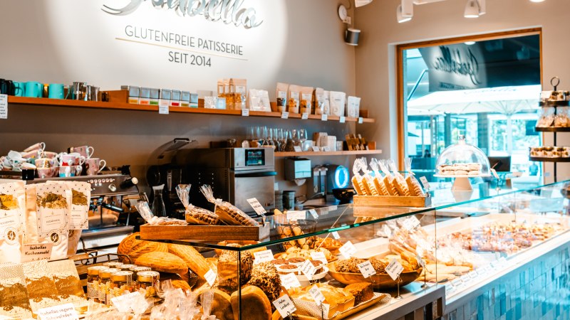 Interior view of Patisserie Isabella with gluten-free baked goods and products. Bright, inviting atmosphere with decorative shelves and counter., © SMG, Sarah Schmid