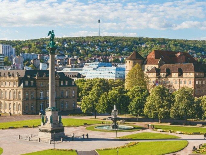 Der Schlossplatz in Stuttgart mit einer S&auml;ule und einem Brunnen im Vordergrund. Im Hintergrund ist der Fernsehturm zu sehen., &copy; Schlienz-Tours GmbH &amp; Co.KG