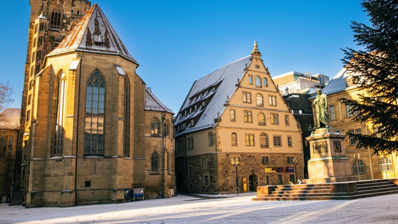 Der Schillerplatz in Stuttgart zeigt den Fruchtkasten und eine Statue, umgeben von historischen Gebäuden im winterlichen Licht., © Stuttgart-Marketing GmbH, Sarah Schmid Der Schillerplatz in Stuttgart zeigt den Fruchtkasten und eine Statue, umgeben von historischen Gebäuden im winterlichen Licht., © Stuttgart-Marketing GmbH, Sarah Schmid