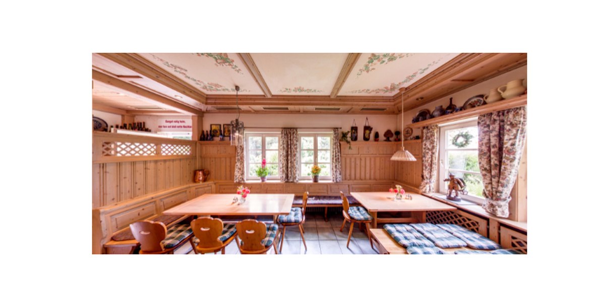 A cozy dining room with wooden furniture, checkered seat cushions and floral curtains. There are floral patterns on the ceiling and ceramics on shelves., © Weingut Karl Wöhrwag A cozy dining room with wooden furniture, checkered seat cushions and floral curtains. There are floral patterns on the ceiling and ceramics on shelves., © Weingut Karl Wöhrwag