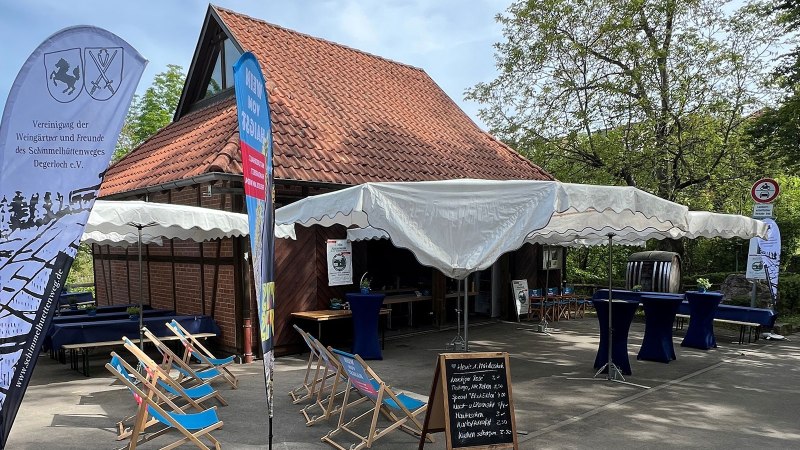 An outdoor area with a marquee, deckchairs and tables in front of a half-timbered building. Signs and banners indicate that an event is taking place., &copy; Frank Nonnenmann