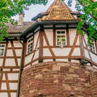 Fachwerkhaus mit roten Ziegeln und steinernem Sockel, umgeben von gr&uuml;nen B&auml;umen im Bohnenviertel., &copy; SMG Thomas Niederm&uuml;ller