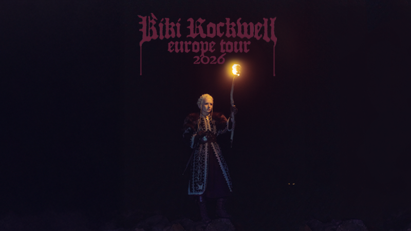 Eine Person in mittelalterlicher Kleidung hält eine Fackel in der Dunkelheit. Darüber steht "Kiki Rockwell Europe Tour 2026" in gotischer Schrift., © links im Bild Eine Person in mittelalterlicher Kleidung hält eine Fackel in der Dunkelheit. Darüber steht "Kiki Rockwell Europe Tour 2026" in gotischer Schrift., © links im Bild