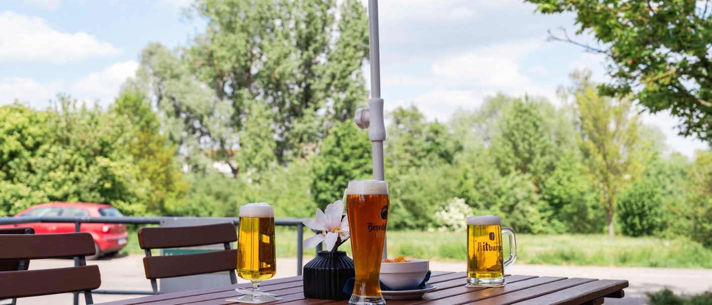 A table on a terrace with three glasses of beer and a bowl of snacks. Trees and a car can be seen in the background., © Plaza INN Stuttgart-Filderstadt A table on a terrace with three glasses of beer and a bowl of snacks. Trees and a car can be seen in the background., © Plaza INN Stuttgart-Filderstadt