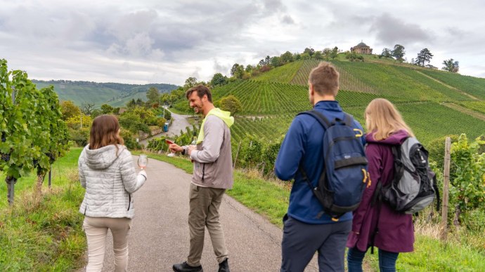 Menschen wandern auf einem Weinweg, halten Weingläser. Im Hintergrund Weinberge und die Grabkapelle auf einem Hügel., © Stuttgart-Marketing GmbH, Martina Denker Menschen wandern auf einem Weinweg, halten Weingläser. Im Hintergrund Weinberge und die Grabkapelle auf einem Hügel., © Stuttgart-Marketing GmbH, Martina Denker