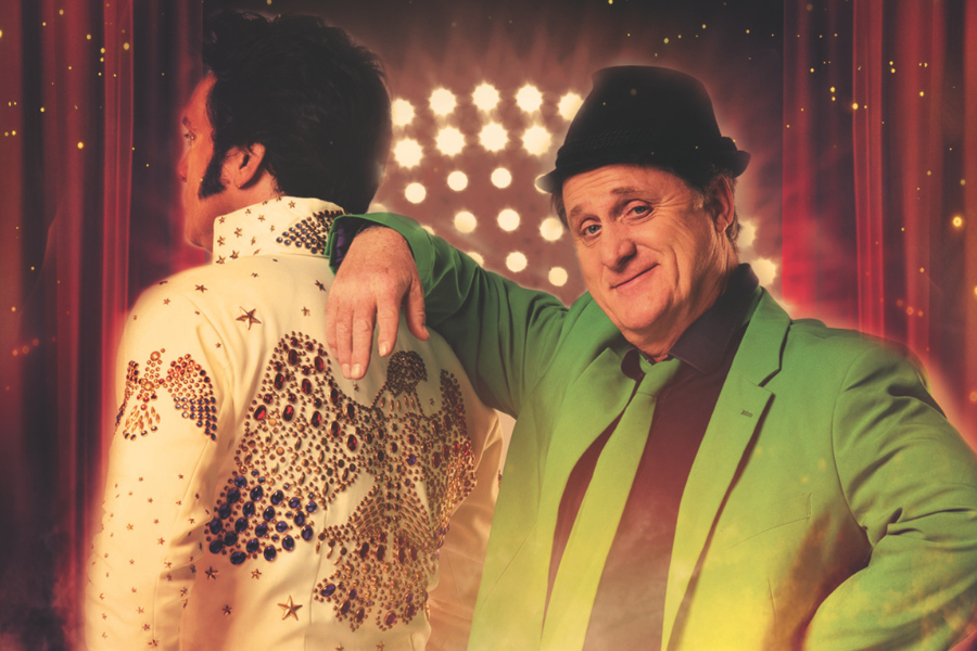 Ein Mann in einem gr&uuml;nen Anzug lehnt l&auml;ssig an einem Elvis-Imitator. Im Hintergrund sind B&uuml;hnenlichter zu sehen, die eine Konzertatmosph&auml;re schaffen., &copy; Friedrichsbau Variet&eacute;