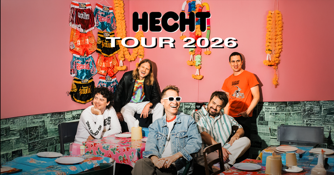 Die Band Hecht posiert fr&ouml;hlich vor einer bunten Wand mit Dekorationen. Der Text "Hecht Tour 2026" ist dar&uuml;ber gelegt., &copy; links im Bild