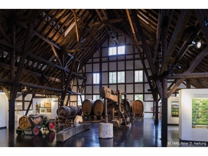 Ein Weinbaumuseum mit großen Holzfässern und einer rustikalen Holzbalkendecke. Historische Weinpressen und Ausstellungsstücke sind zu sehen., © Stuttgart Marketing GmbH Ein Weinbaumuseum mit großen Holzfässern und einer rustikalen Holzbalkendecke. Historische Weinpressen und Ausstellungsstücke sind zu sehen., © Stuttgart Marketing GmbH
