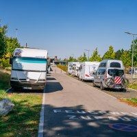 Wohnmobilstellplatz in Fellbach mit geparkten Wohnmobilen und Autos, umgeben von Bäumen und klarem Himmel. Auf der Straße steht 'Feuerwehrzufahrt'., © Stuttgart-Marketing GmbH, Thomas Niedermüller