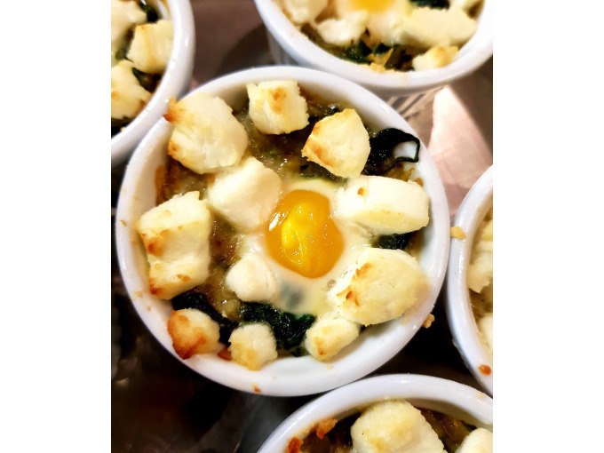 Small casserole dish with baked egg, spinach and cheese. The dish is baked to a golden brown and looks appetizing., © Kultweine-Kochwelten-Kunstücke - Kochschule Sonja Lenz Small casserole dish with baked egg, spinach and cheese. The dish is baked to a golden brown and looks appetizing., © Kultweine-Kochwelten-Kunstücke - Kochschule Sonja Lenz