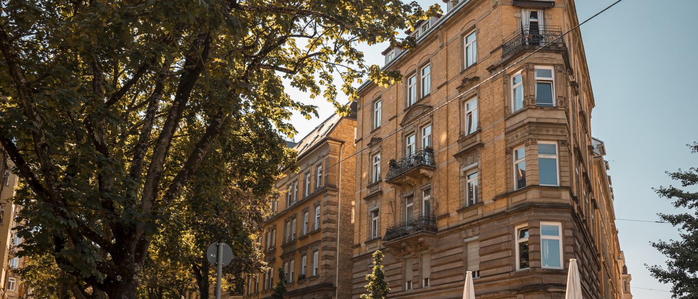 Historisches Gebäude an einer Straßenecke, umgeben von Bäumen und geparkten Autos. Sonniger Tag mit klarem Himmel., © SMG Stuttgart Marketing GmbH - Sarah Schmid Historisches Gebäude an einer Straßenecke, umgeben von Bäumen und geparkten Autos. Sonniger Tag mit klarem Himmel., © SMG Stuttgart Marketing GmbH - Sarah Schmid