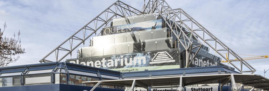 The Carl-Zeiss Planetarium Stuttgart with modern glass and steel architecture, advertising banners and a clear sky in the background., © Stuttgart-Marketing GmbH, Sarah Schmid