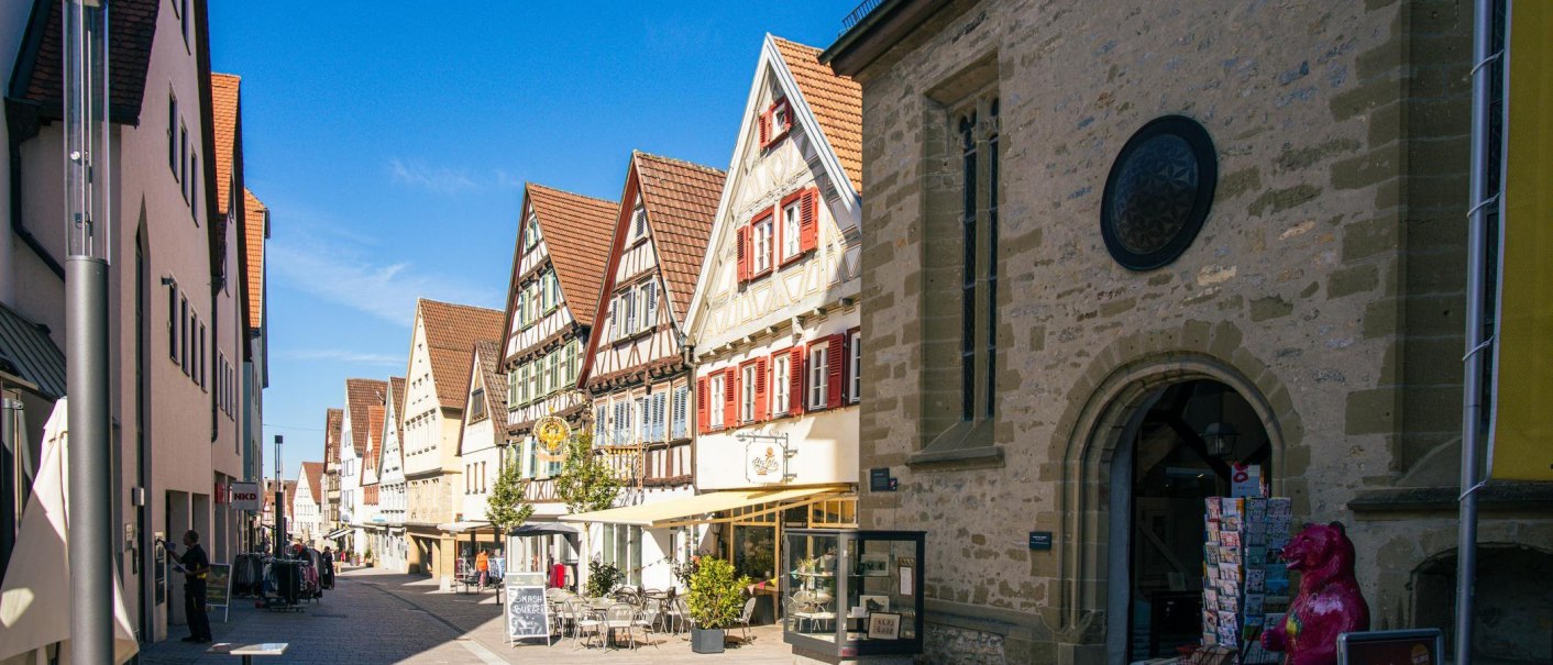 Half-timbered houses in the old town of Marbach am Neckar. The street is bustling with stores and cafés. A sunny day with a clear sky., © Stuttgart-Marketing GmbH, Sarah Schmid Half-timbered houses in the old town of Marbach am Neckar. The street is bustling with stores and cafés. A sunny day with a clear sky., © Stuttgart-Marketing GmbH, Sarah Schmid