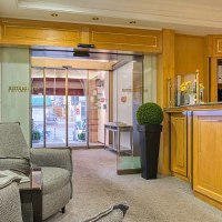 Reception area with wooden furniture, seating and glass door. Inviting atmosphere with plants and decoration., &copy; Centro Hotels