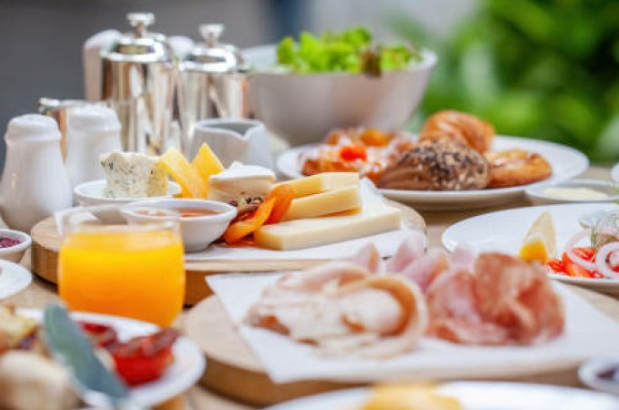 Ein reichhaltiger Brunch mit Käse, Aufschnitt, Croissants und Orangensaft auf einem Tisch im Freien., © Cool-Tours StattReisen
