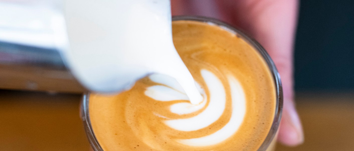 Nahaufnahme eines Cappuccinos, in den Milch gegossen wird, um ein Latte Art-Muster zu erzeugen., © Sven Weber Nahaufnahme eines Cappuccinos, in den Milch gegossen wird, um ein Latte Art-Muster zu erzeugen., © Sven Weber