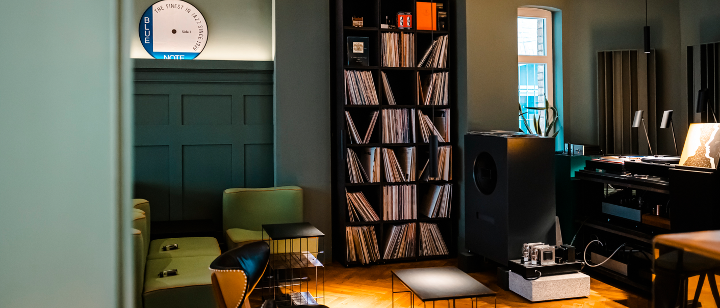 Stilvoller Raum mit Plattensammlung, Lautsprecher, gemütlichen Sesseln und einem Fenster. Ein Schild mit 'Blue Note' ist an der Wand., © Stuttgart-Marketing GmbH, Sarah Schmid Stilvoller Raum mit Plattensammlung, Lautsprecher, gemütlichen Sesseln und einem Fenster. Ein Schild mit 'Blue Note' ist an der Wand., © Stuttgart-Marketing GmbH, Sarah Schmid