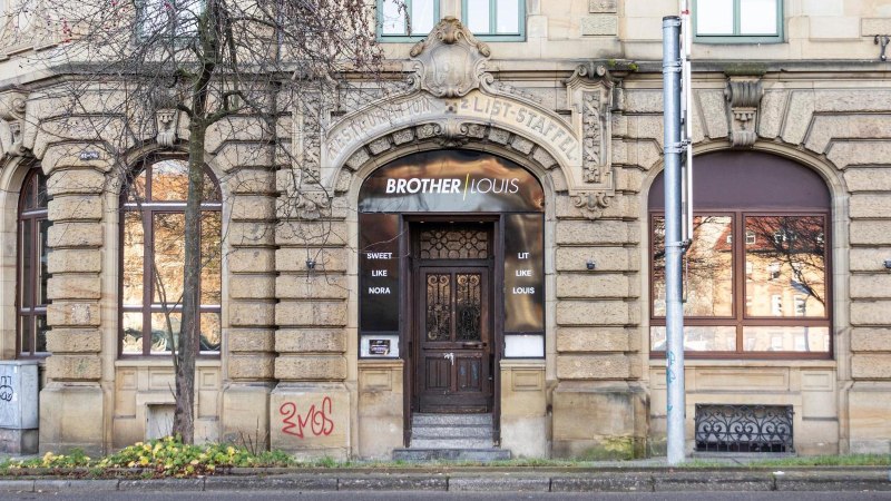 Ein historisches Gebäude mit dem Schriftzug 'Brother Louis' über der Eingangstür. Die Fassade ist aus Stein mit dekorativen Elementen., © Stuttgart-Marketing GmbH, Sarah Schmid Ein historisches Gebäude mit dem Schriftzug 'Brother Louis' über der Eingangstür. Die Fassade ist aus Stein mit dekorativen Elementen., © Stuttgart-Marketing GmbH, Sarah Schmid