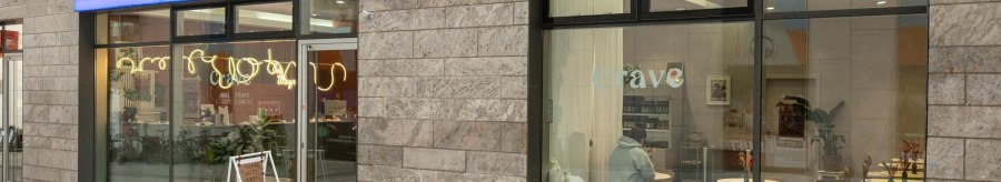 Large window fronts that offer a view of the caf&eacute; inside: Wooden tables, white cushions., &copy; Stuttgart-Marketing GmbH, Sarah Schmid