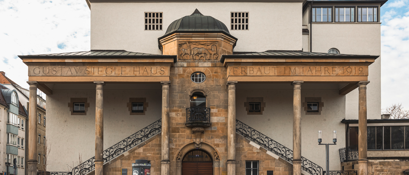 Das Gustav-Siegle-Haus zeigt eine Fassade mit Säulen und der Inschrift 'GUSTAV SIEGLE HAUS ERBAUT IM JAHRE 1912'. Es hat ein klassisches Design., © Stuttgart-Marketing GmbH, Sarah Schmid