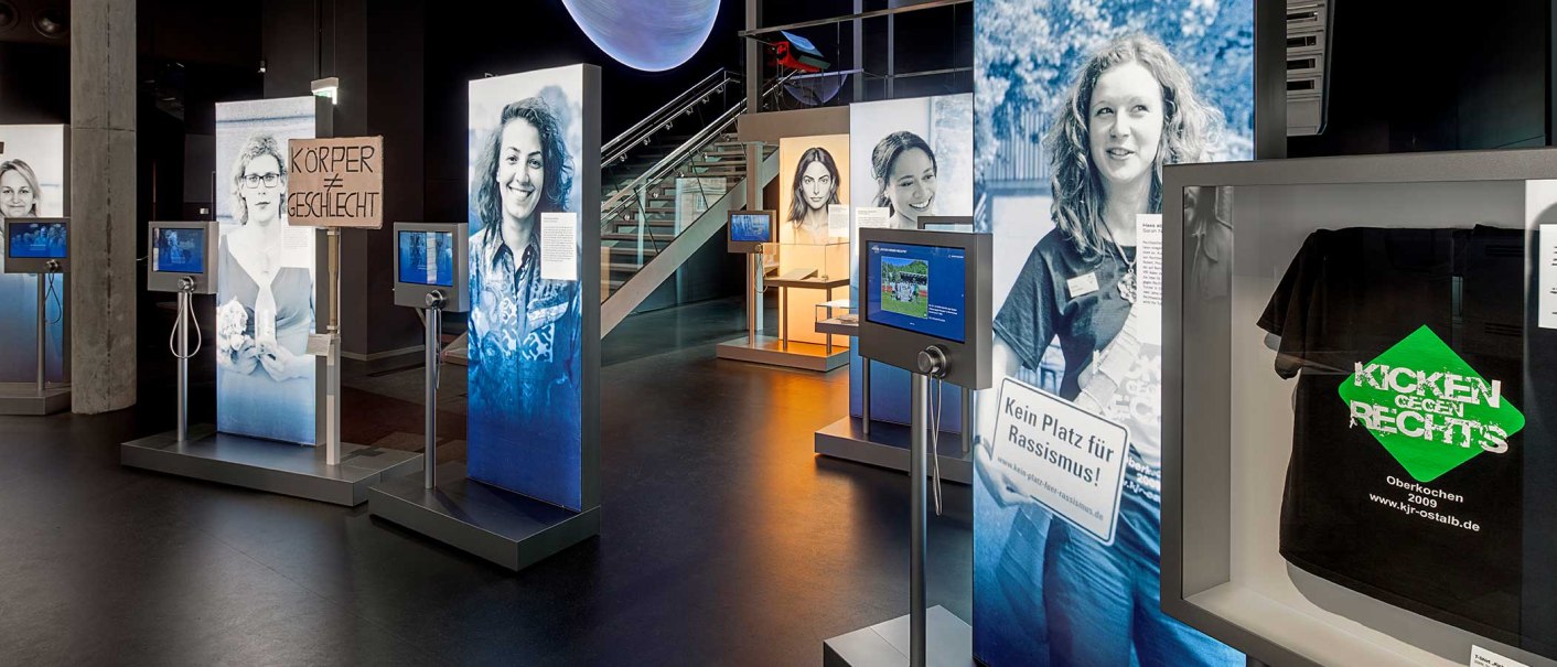 Eine Ausstellung mit großen Fotos, interaktiven Bildschirmen und Schildern zu sozialen Themen wie Rassismus und Geschlechtergleichheit., © Haus der Geschichte Baden-Württemberg, Daniel Stauch Photography