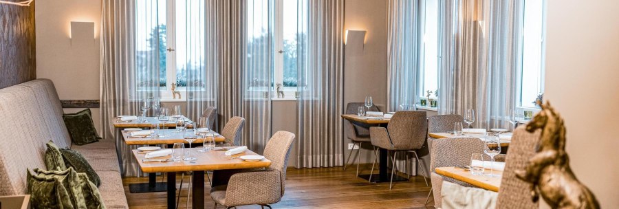 Elegantes Restaurant mit gedeckten Tischen, grauen Vorhängen und Holzboden. Dezente Beleuchtung und stilvolle Dekoration schaffen eine gemütliche Atmosphäre., © New Josch, Stuttgart Elegantes Restaurant mit gedeckten Tischen, grauen Vorhängen und Holzboden. Dezente Beleuchtung und stilvolle Dekoration schaffen eine gemütliche Atmosphäre., © New Josch, Stuttgart