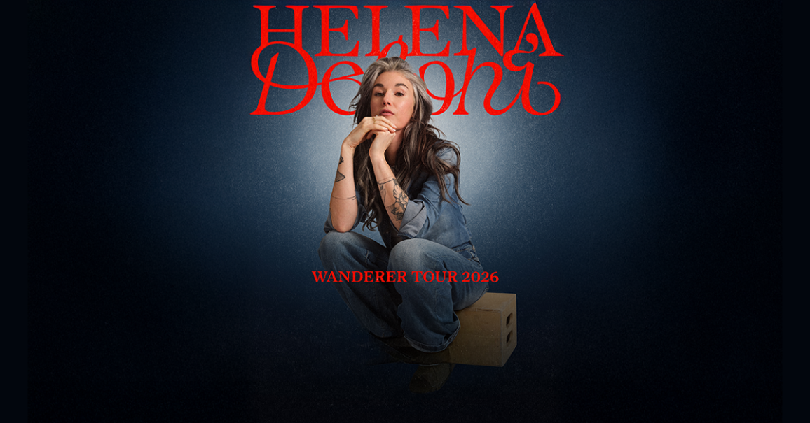Eine Frau in Jeans sitzt auf einem Holzkasten vor einem dunklen Hintergrund. Oben steht "Helena Delphi" und unten "Wanderer Tour 2026" in roter Schrift., &copy; links im Bild