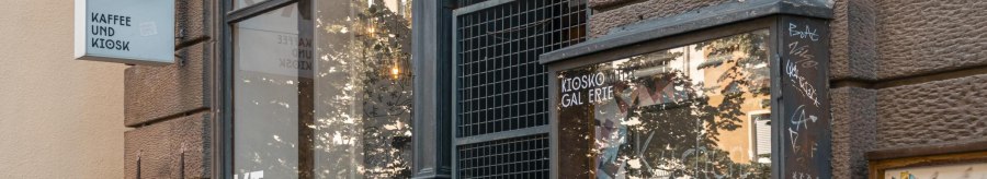 Ein Kiosk mit der Aufschrift 'Kiosko Kaffee und Kiosk'. Die Fassade ist mit Graffiti bedeckt, und das Schaufenster spiegelt die Umgebung wider., &copy; SMG, Sarah Schmid