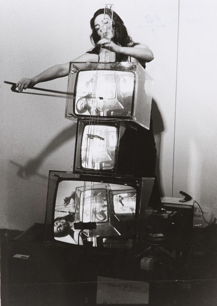 Charlotte Moorman spielt ein Cello aus gestapelten Fernsehern, eine Performance von Nam June Paik, fotografiert 1974 in K&ouml;ln., &copy; Concerto for TV Cello (Nam June Paik 1971), performed von Charlotte Moorman am 6.7.1974 in K&ouml;ln, fotografiert von Hanns Sohm, Staatsgalerie Stuttgart, Archiv Sohm
