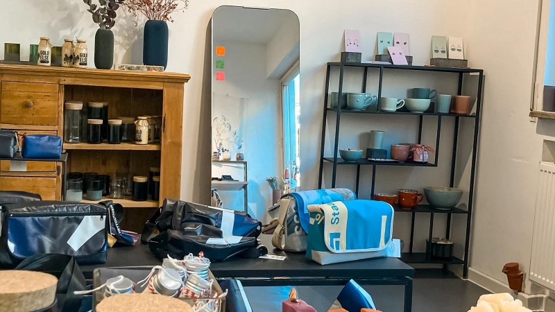 Ein Raum mit Holzschrank, Spiegel, Regalen mit Keramik und Taschen. Fenster mit blauem Licht. Dekorative Elemente auf dem Schrank., &copy; S&uuml;dstatt, Stuttgart