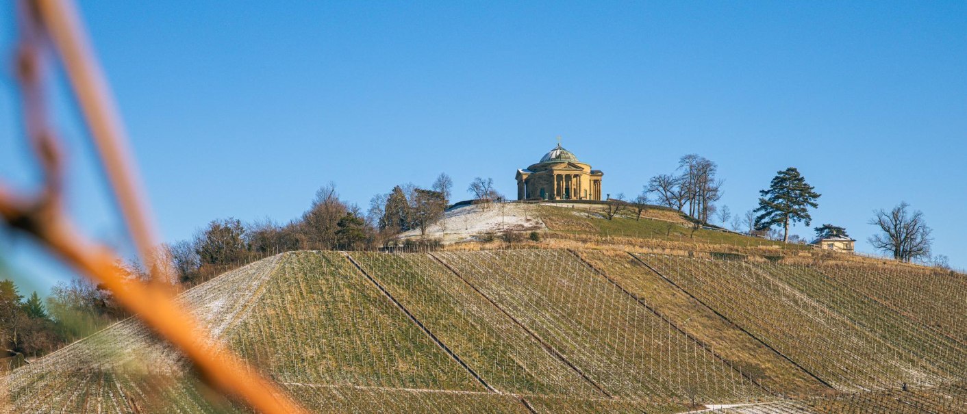 Die Grabkapelle auf dem W&uuml;rttemberg thront auf einem H&uuml;gel, umgeben von kahlen Weinbergen unter klarem, blauem Himmel., &copy; Stuttgart-Marketing GmbH, Sarah Schmid