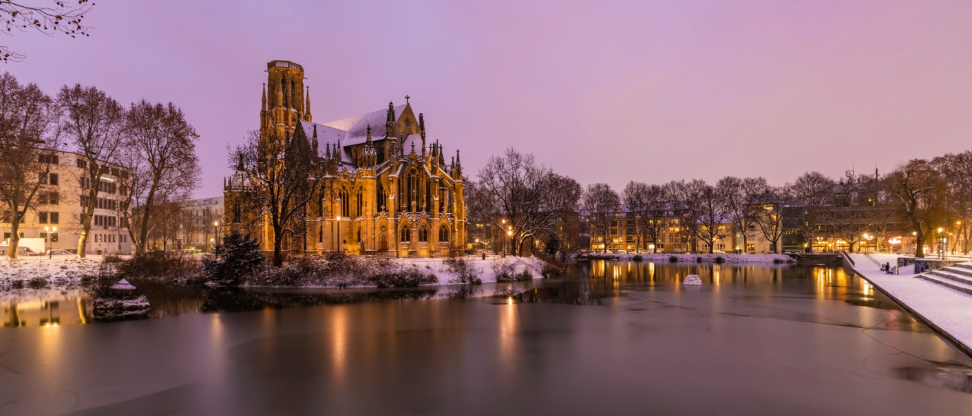 Die Johanneskirche am Feuersee in winterlicher Abendstimmung, umgeben von Schnee und beleuchtetem Wasser., © Werner Dietrich Die Johanneskirche am Feuersee in winterlicher Abendstimmung, umgeben von Schnee und beleuchtetem Wasser., © Werner Dietrich