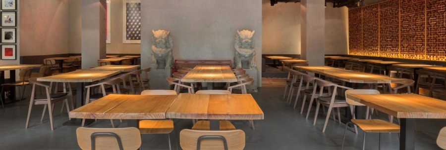 Modernes Restaurant mit Holztischen, Stühlen und asiatischen Dekorationen. Dezente Beleuchtung und kunstvolle Wandgestaltung schaffen eine einladende Atmosphäre., © Breitengrad17, Stuttgart