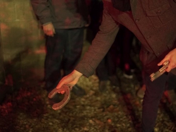 A person is holding a horseshoe. The scene is dimly lit, possibly at an outdoor event or game., © Cool-Tours StattReisen A person is holding a horseshoe. The scene is dimly lit, possibly at an outdoor event or game., © Cool-Tours StattReisen