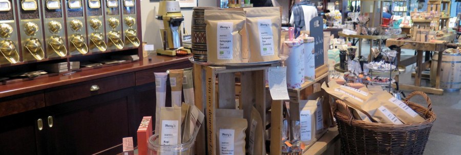 Sales room of a coffee roastery with golden coffee dispensers, coffee bags and various products on wooden tables and shelves., © © Stuttgart-Marketing GmbH, Lara Seeger