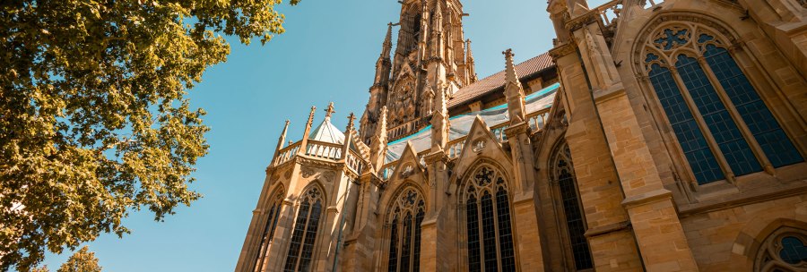 St. John's Church in Stuttgart with Gothic architecture, surrounded by trees and a bright blue sky., &copy; SMG Stuttgart Marketing GmbH - Sarah Schmid