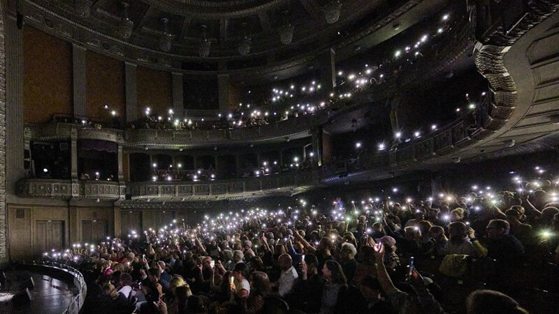 Ein Konzertsaal voller Menschen, die ihre Handys mit eingeschaltetem Licht hochhalten, um eine magische Atmosphäre zu erzeugen., © Württembergische Staatstheater Stuttgart