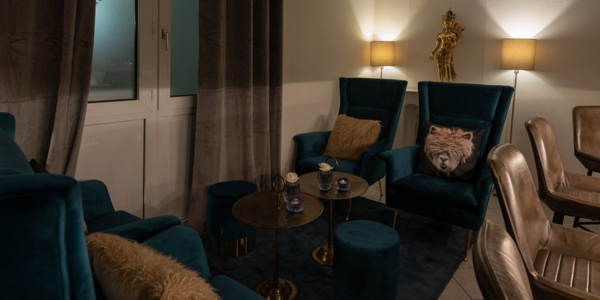 Gemütliche Bar-Lounge mit blauen Sesseln, goldenen Tischen und gedämpfter Beleuchtung. Dekorative Kissen und eine goldene Statue ergänzen das Ambiente., © Hotel Princess Gemütliche Bar-Lounge mit blauen Sesseln, goldenen Tischen und gedämpfter Beleuchtung. Dekorative Kissen und eine goldene Statue ergänzen das Ambiente., © Hotel Princess