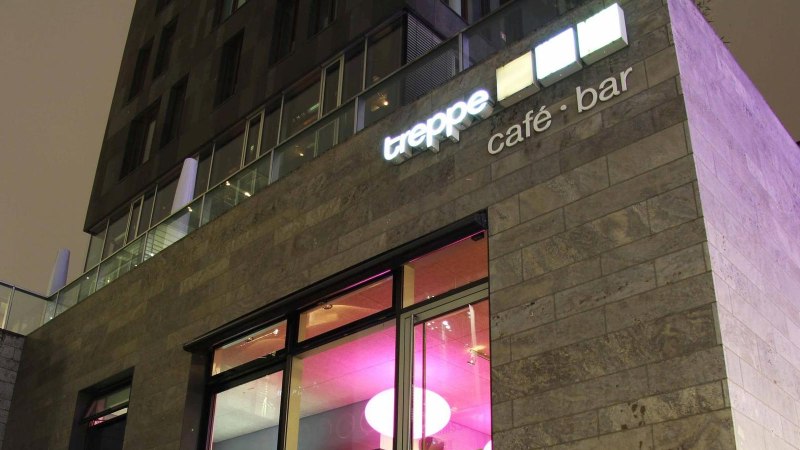 Modernes Gebäude mit der Aufschrift 'treppe café · bar' und beleuchteten Fenstern in der Nacht., © Café Treppe, Stuttgart
