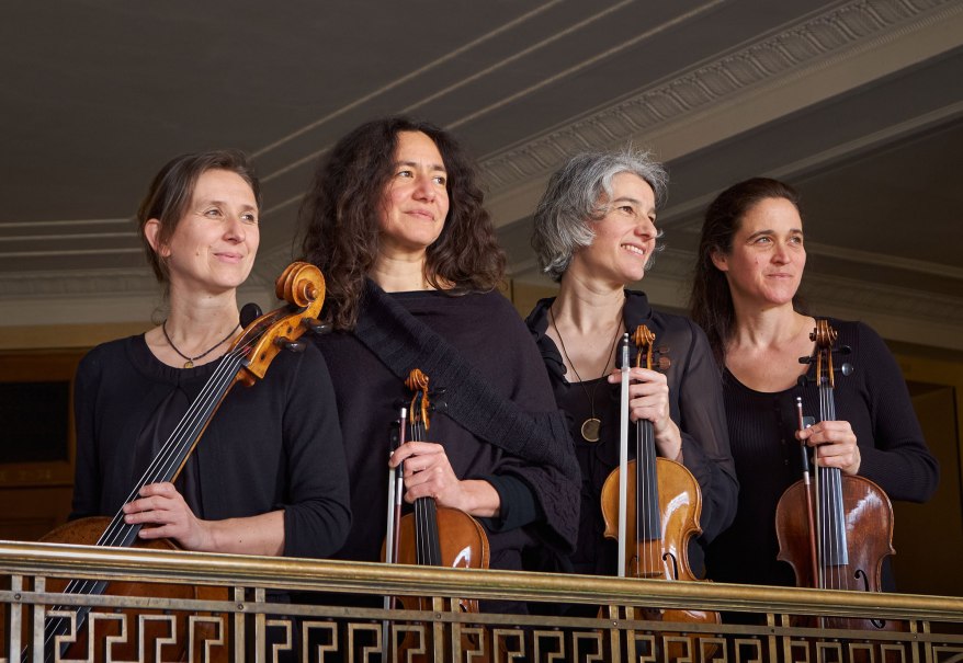 Vier Musikerinnen des Anthea Quartetts stehen mit ihren Streichinstrumenten auf einem Balkon und lächeln in die Ferne., © Mendelssohn Quartett Vier Musikerinnen des Anthea Quartetts stehen mit ihren Streichinstrumenten auf einem Balkon und lächeln in die Ferne., © Mendelssohn Quartett