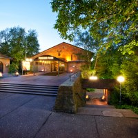 Entrance to Perkins Park in Stuttgart at dusk, surrounded by trees and illuminated with lanterns., © PerkinsPark Entrance to Perkins Park in Stuttgart at dusk, surrounded by trees and illuminated with lanterns., © PerkinsPark